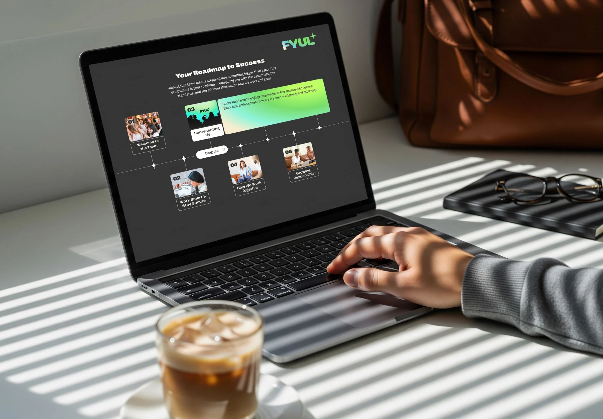 Person using a laptop displaying a FYUL learning roadmap, with an iced coffee nearby.