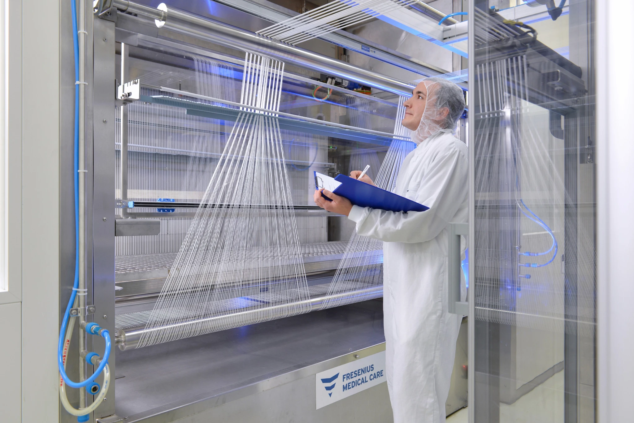 Fresenius: Laboratory technician inspecting equipment in a modern server or production facility.